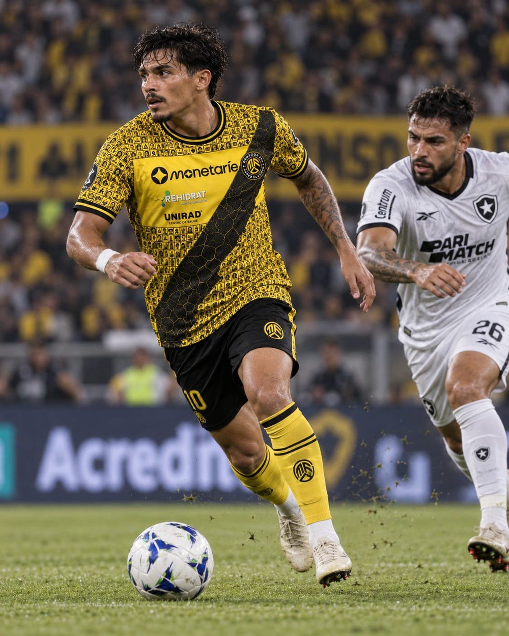 Foto de lance aberto com jogador, bola e adversário